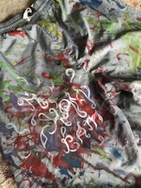 a gray sweatshirt with colorful paint splatters on it