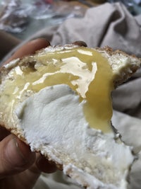 a person is holding a piece of bread with cream on it